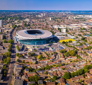 Luftaufnahme eines gro&szlig;en Stadions inmitten Londons, umgeben von dicht bebauten Wohnvierteln und gr&uuml;nen Parks.